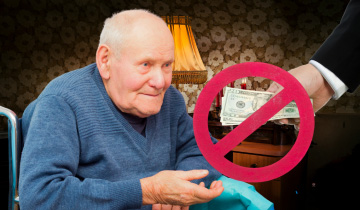 Das Symbolbild für Pflegegeldkürzungen zeigt einen älteren Mann im Rollstuhl, der von einer Person außerhalb des Bildes Geld entgegennehmen will, das Geld ist von einem Verbotsschild überlagert und durchgestrichen