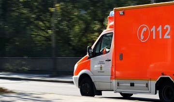 Krankenwagen fährt von rechts ins Bild über eine Straße