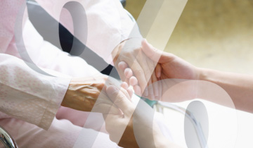 Ältere Person hält die unterstützende Hand einer Pflegekraft als Symbol für Betreuung, Fürsorge und finanzielle Entlastung durch den Pflegepauschbetrag
